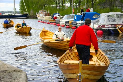 Puiset soutuveneet satama-altaassa. Taustalla moottoriveneitä.