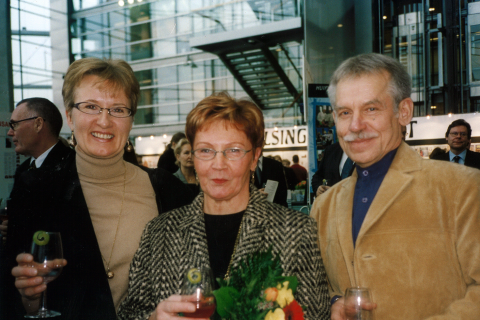 Kolme henkilöä poseeraa kameralle.