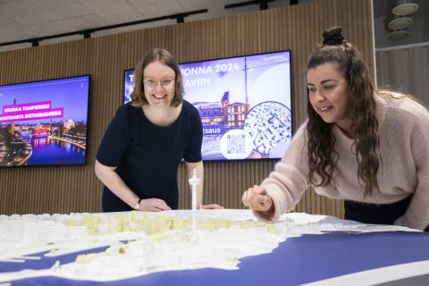 Kaksi henkilöä katselee pöydällä olevaa kohokuvioista karttaa, jossa on pystyssä Näsinneula.