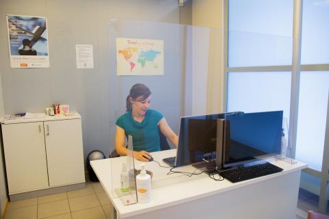 A woman sits behind a desk.