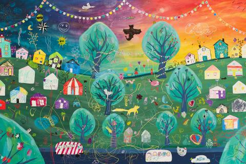 Painted community art work with a view of a village with colorful houses.