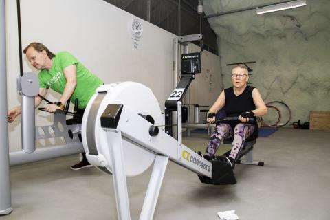 Nainen soutulaitteella, mies kuntoilee vieressä.