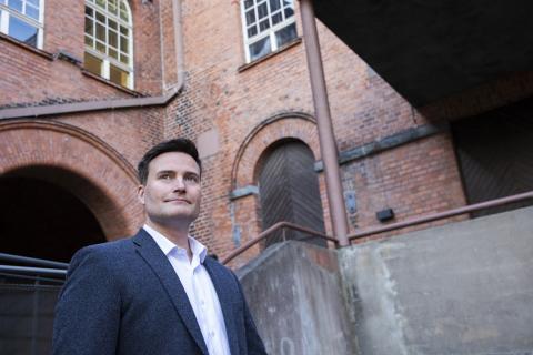 Henkilö seisoo Frenckellin sisäpihalla punatiilisessä ja betonisessa ympäristössä.