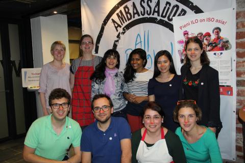 Group of Tampere ambassadors posing togehter under a Ambassadors-sign.