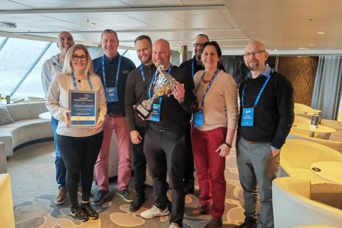 Ryhmä henkilöitä, jotka vastaanottivat pokaalin. 