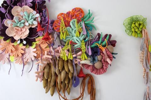 Värikkäistä langoista tehtyjä kukkia muistuttavia taideteoksia. 