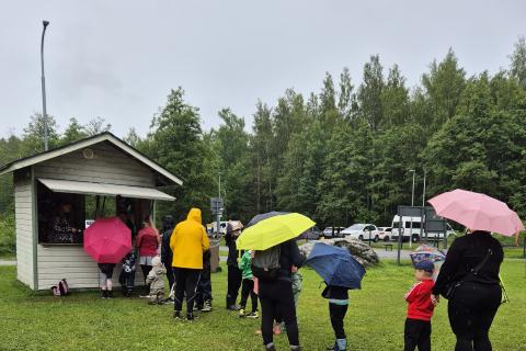 People queuing for food on the lawn.