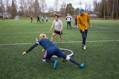 Three Roundnet players play the ball game on the grass pitch in Koivistonkylä.