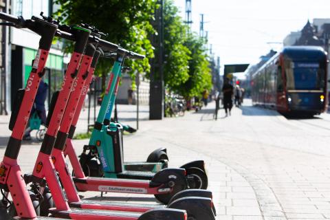 Sähköpotkulaudat pysäköintiruudussa siistissä rivissä.