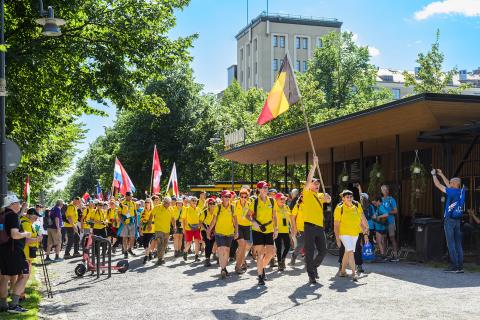 Joukko urheilijoita kävelee pitkin Hämeenpuistoa.