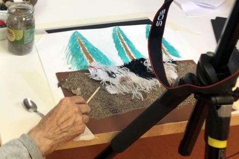 Iäkäs ihminen tekee animaatiota koirahahmolla.