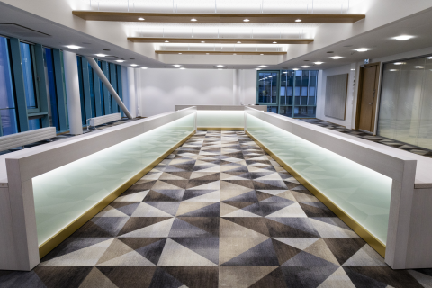 A hall dominated by a large light-colored table and a carpet with triangles.