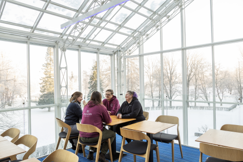Four people are sitting at a table in Tampere Hall.