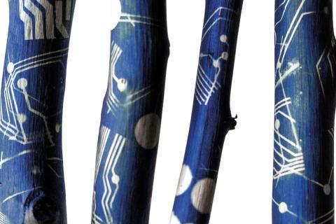 Maalattuja oksia, sinisellä pohjalla valkoisia kuvioita.