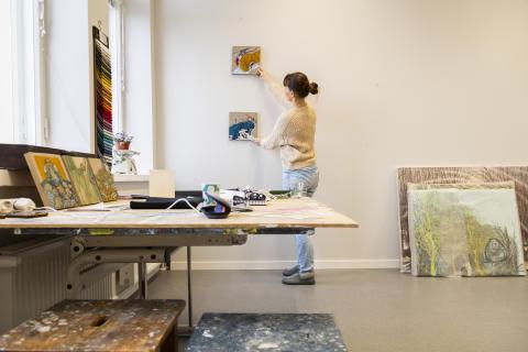 Kristiina Sario arranges her paintings in the workroom of the Nekala Cultural Center.