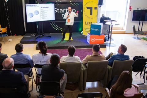 A person on stage pitching their startup to the judges.