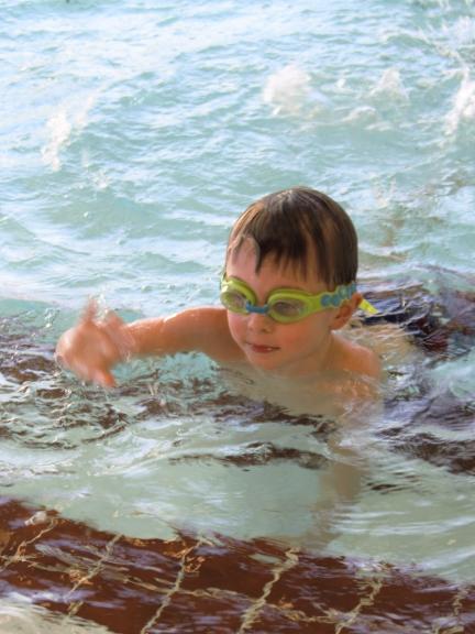 A young boy in the swimming pool.