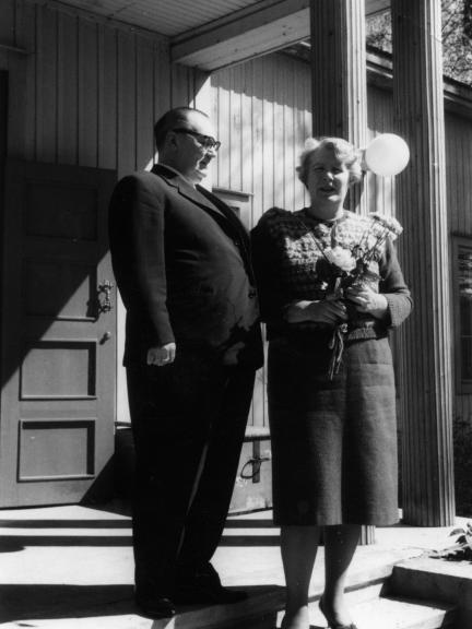 Gunvor and Torsten Ekroos stand in front of Haihara Manor in a black and white photo.
