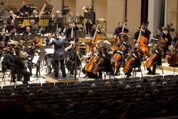 Orkesterinjohtaja ja soittajia lavalla soittamassa Tampere Biennalessa.